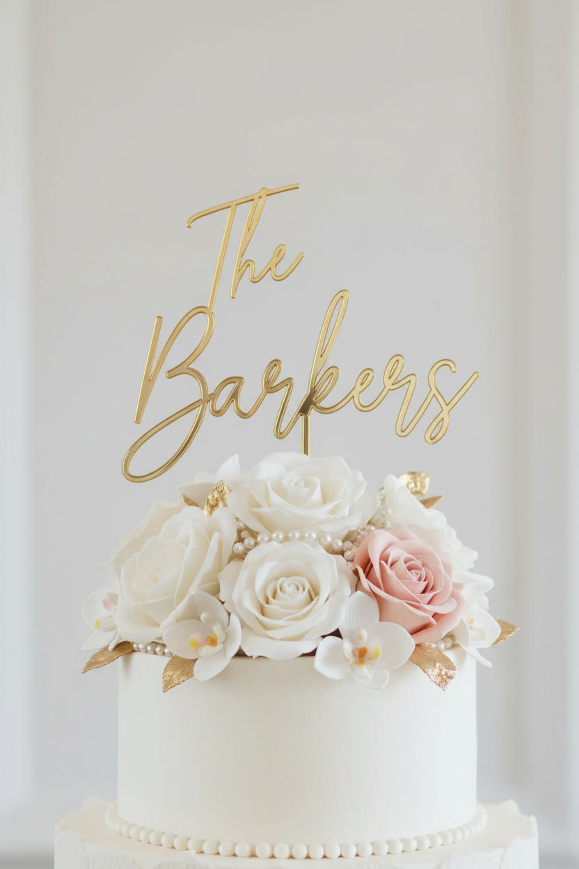 Wedding cake toppers personalized acrylic name sign on white wedding cake with floral decorations on soft light background