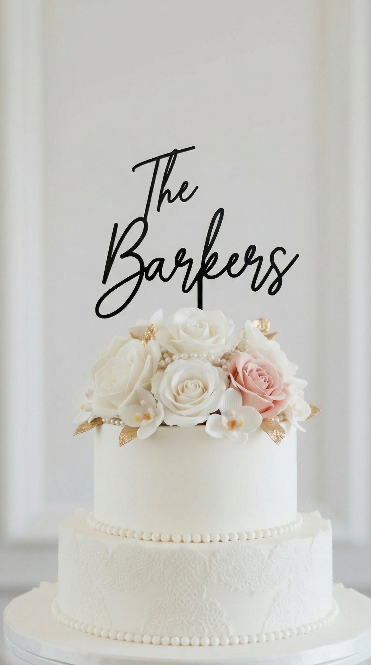 Wedding cake toppers personalized acrylic name sign on two tier wedding cake with floral decorations on white background